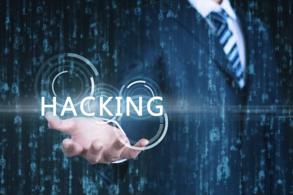 Young,Businessman,Shows,The,Word,"hacking",On,His,Hand,With