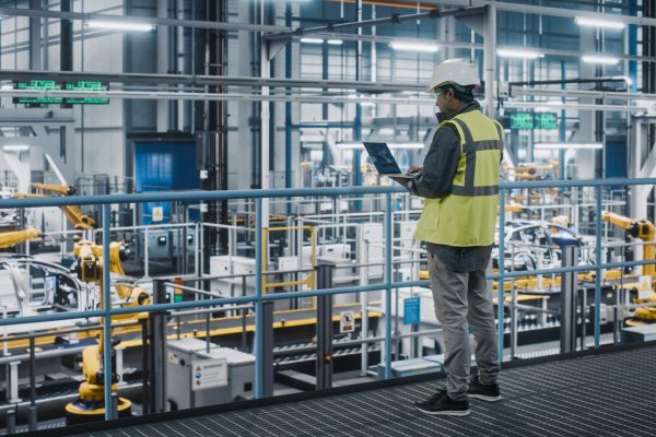Car,Factory,Engineer,In,High,Visibility,Vest,Using,Laptop,Computer.
