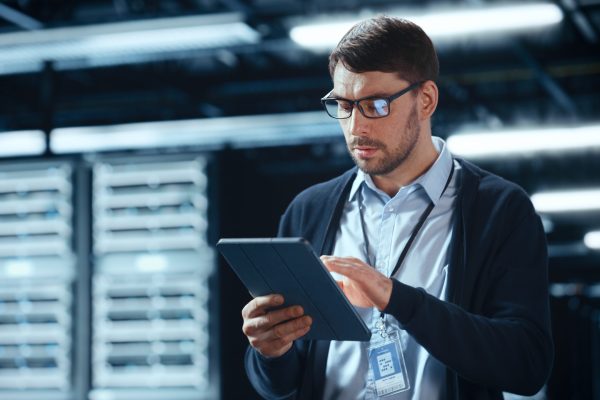 Male,It,Specialist,Walks,Between,Row,Of,Operational,Server,Racks