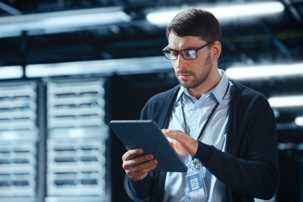 Male,It,Specialist,Walks,Between,Row,Of,Operational,Server,Racks