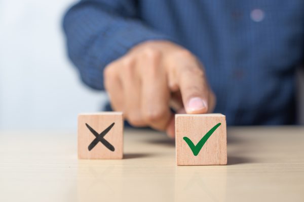 A,Man,Choosing,Between,A,Checkmark,And,An,'x',Symbol